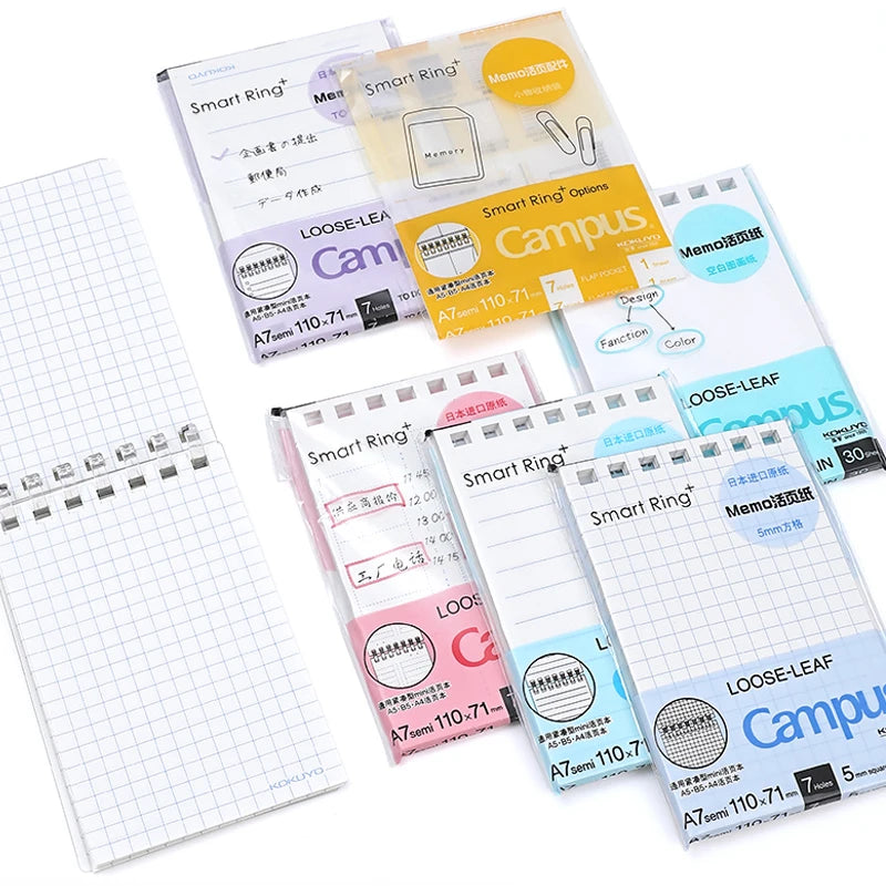 Collection of loose-leaf notebooks with various designs and colors on a white background.