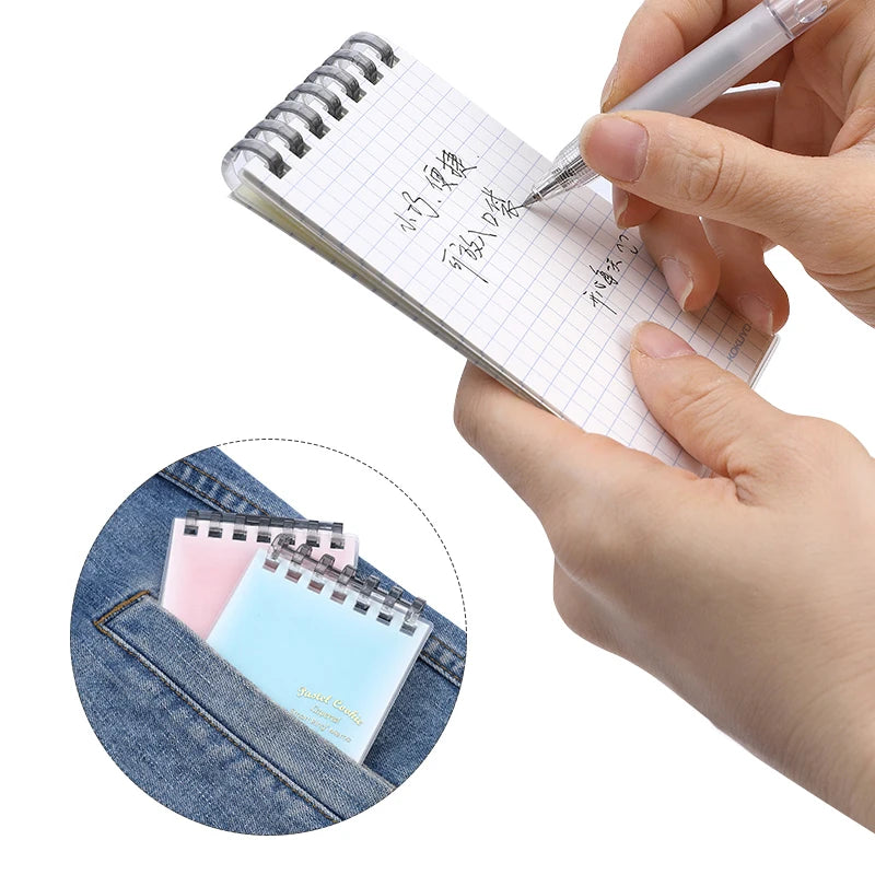 Hand writing in a small spiral notebook with a pen, with an inset showing the notebooks in a pocket.
