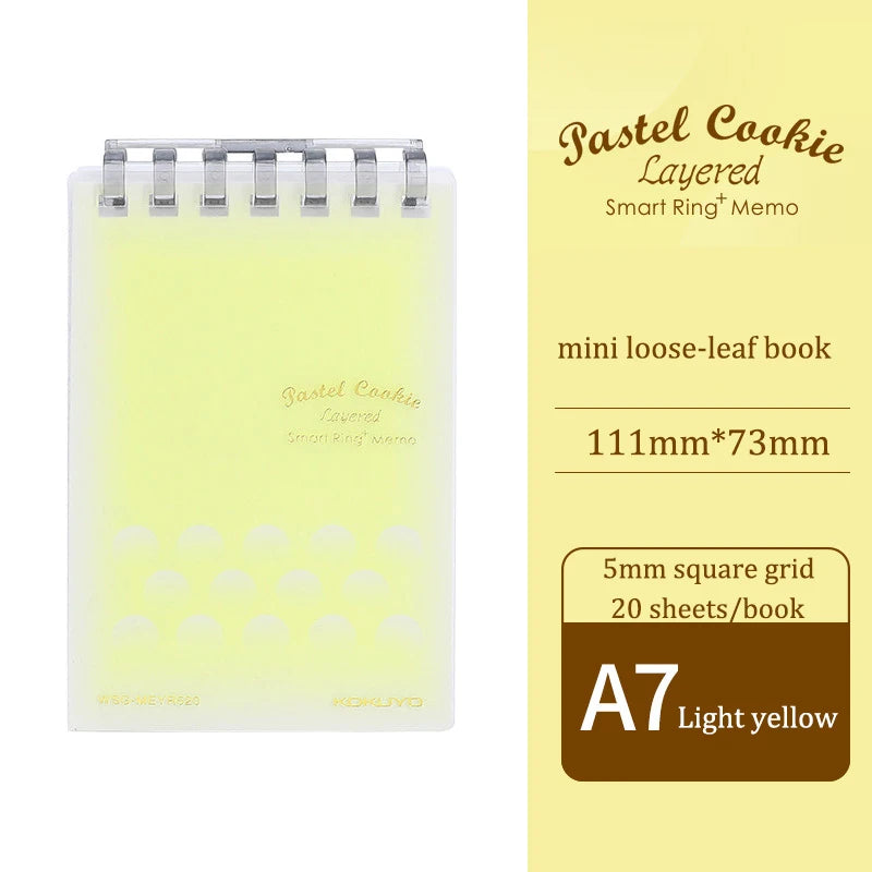 Light yellow mini loose-leaf book with grid on a white background