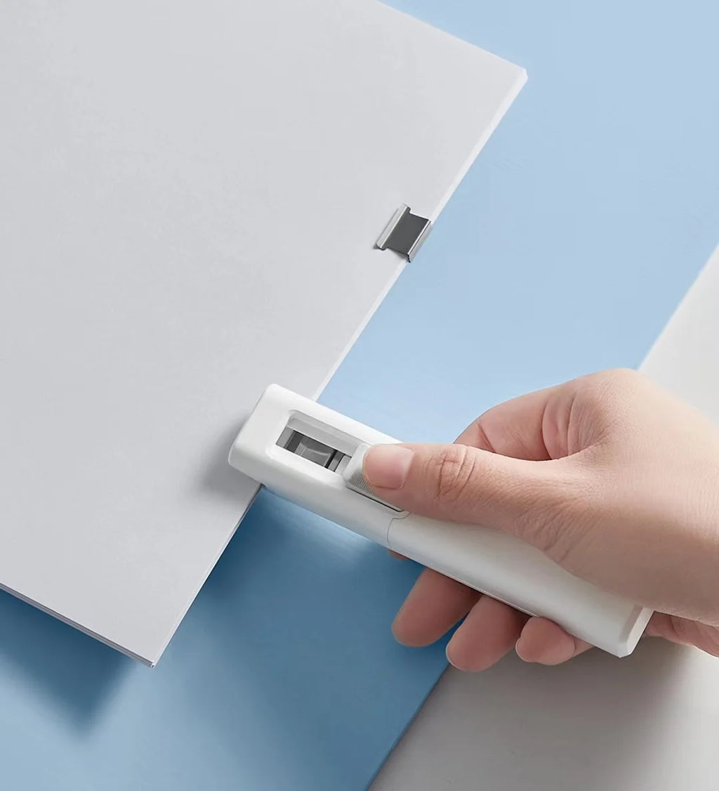 Bentopop hand holding a white paper clipper on a light blue background